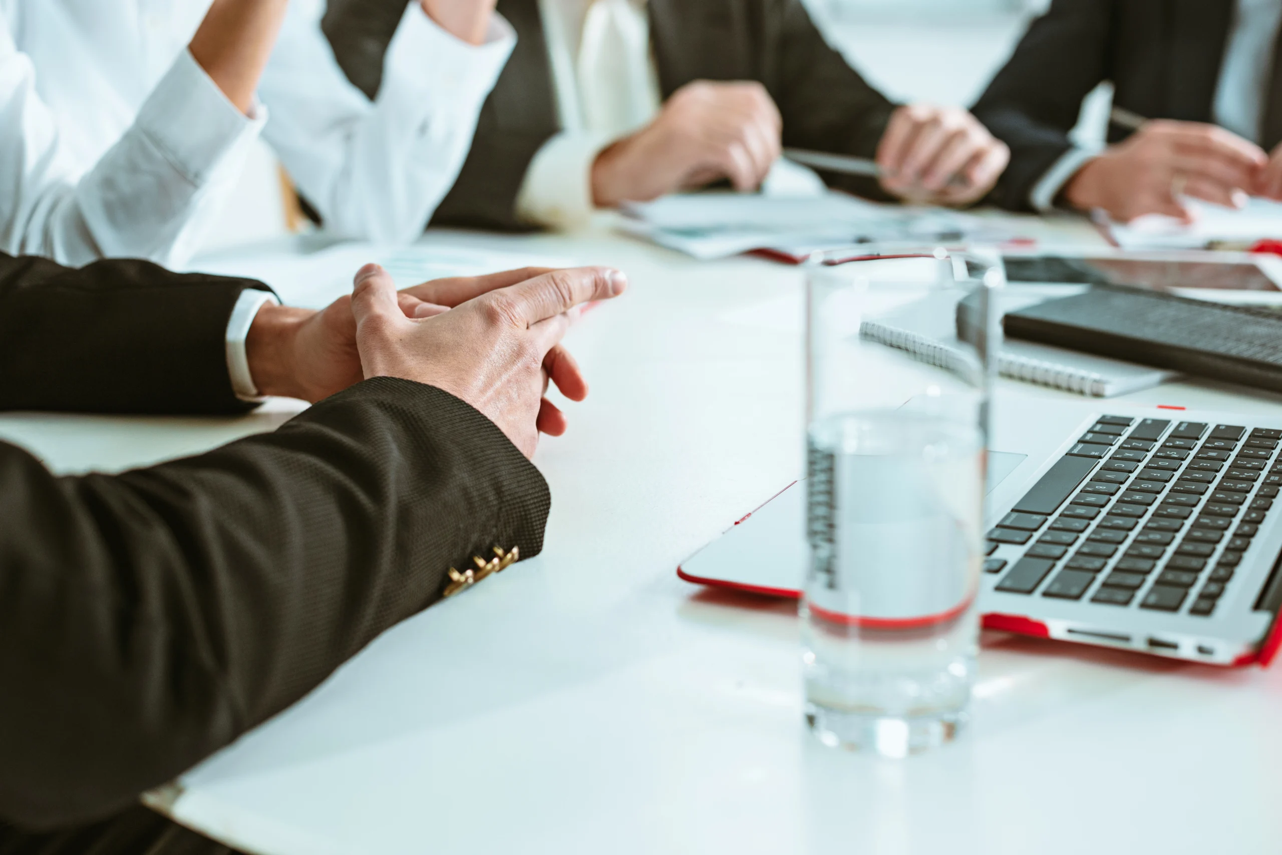 Une réunion d'affaires où plusieurs professionnels discutent de l'optimisation fiscale pour une entreprise. Ils sont autour d'une table de conférence, avec des ordinateurs portables et des documents. Un graphique financier est projeté à l'écran, illustrant les stratégies pour améliorer l'efficacité fiscale de l'entreprise. L'ambiance est collaborative et professionnelle, mettant en avant le travail d'équipe et la prise de décembre.