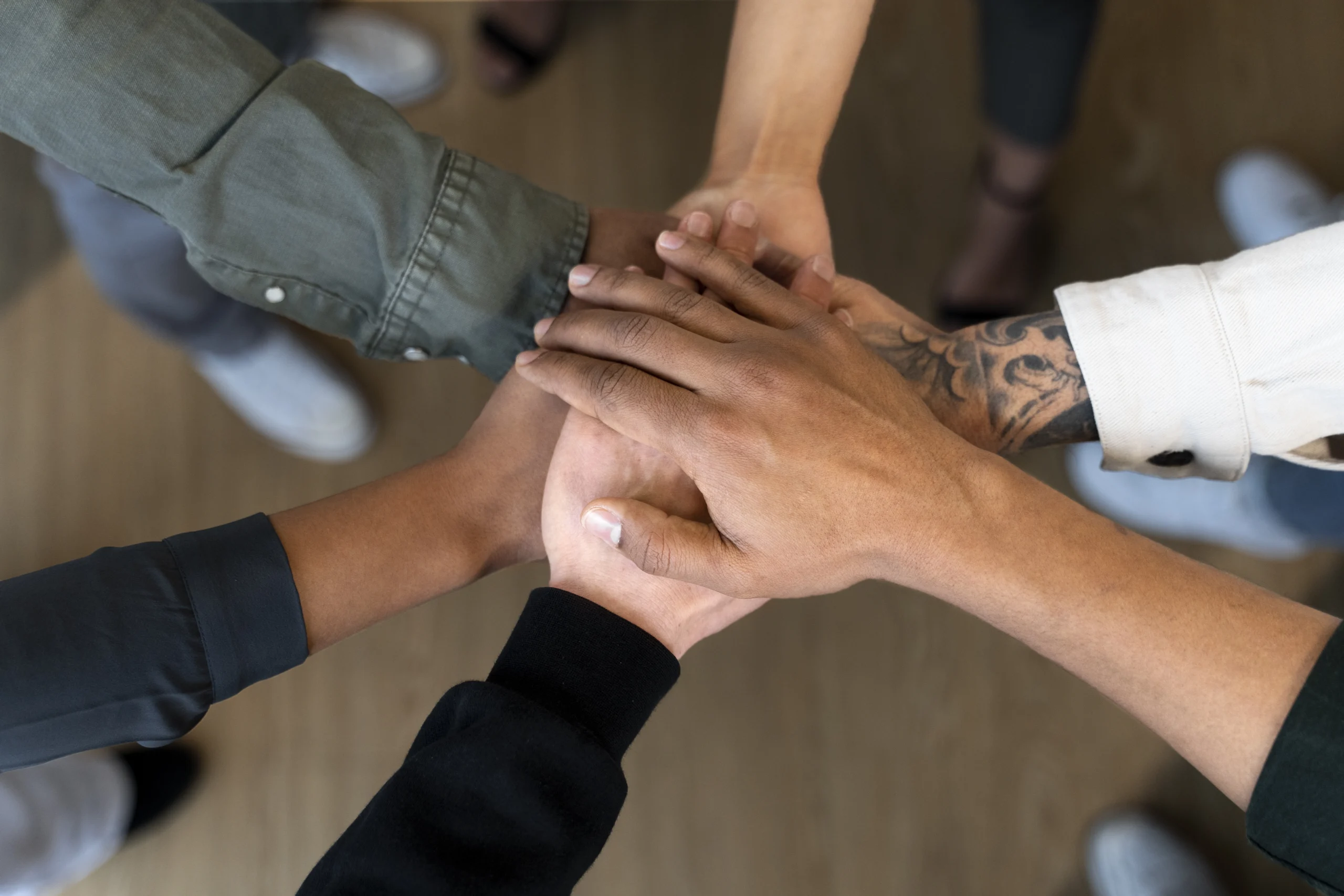 Plusieurs mains superposées symbolisant la confiance et l'engagement. Cette image évoque l'idée d'une collaboration solide et fiable, où notre équipe s'engage à accompagner le client avec sérieux et dévouement.